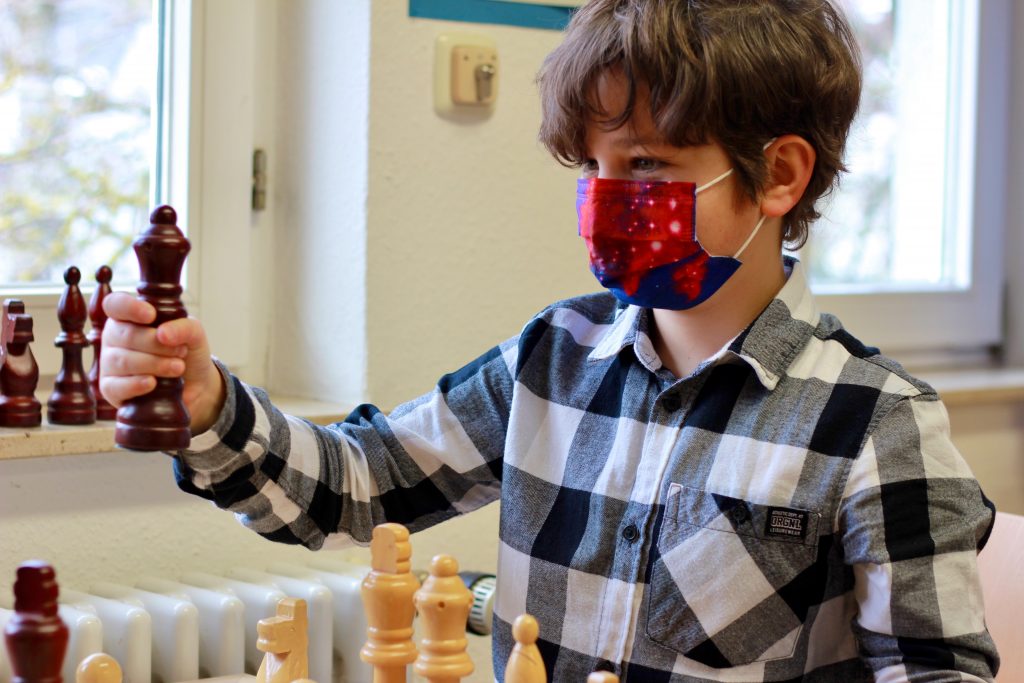 Foto von Schüler mit Schachfigur
